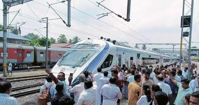 വ​ന്ദേ ഭാ​ര​ത് ട്രെ​യി​ൻ സ്വീ​ക​ര​ണ​ത്തി​നി​ടെ അ​പ്പം വി​ത​ര​ണം ചെ​യ്ത് ബി​ജെ​പി